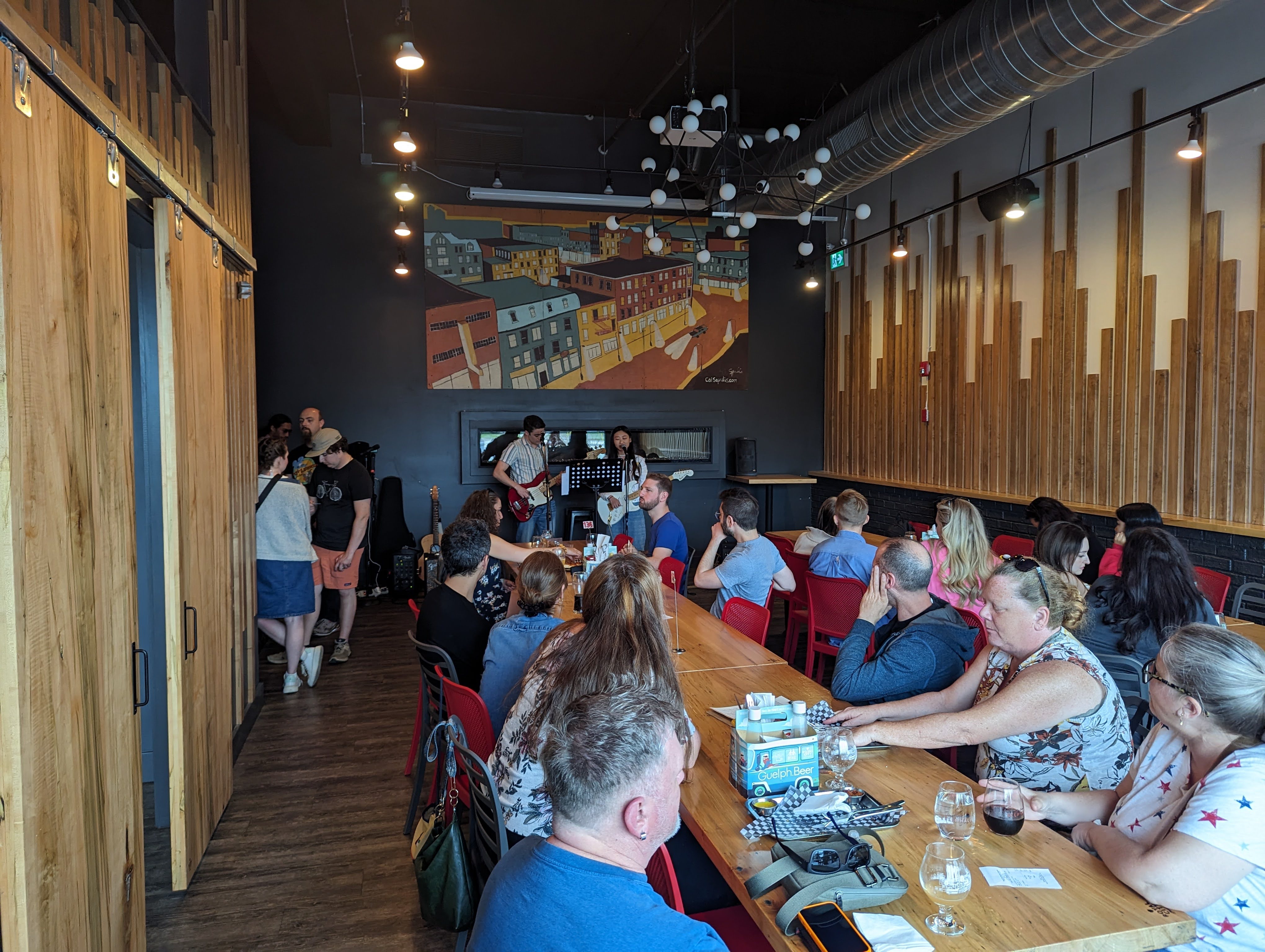 A picture of a room in Royal City Brewing, with artists playing in the background